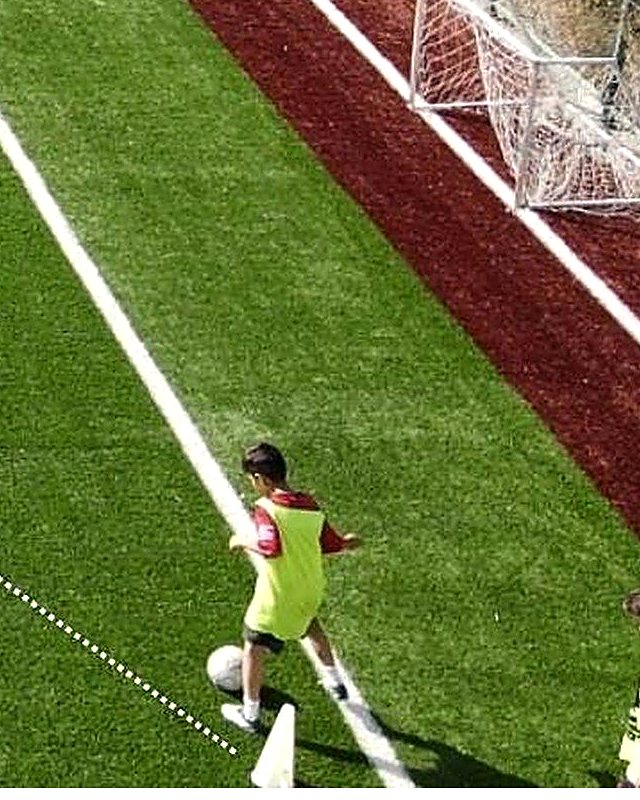 A young player strikes a pass toward a cone during a CT² technical session
